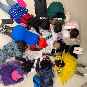 des élèves qui font du dessin tous ensemble au sol